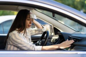 Donna soffre caldo in auto, si asciuga la fronte