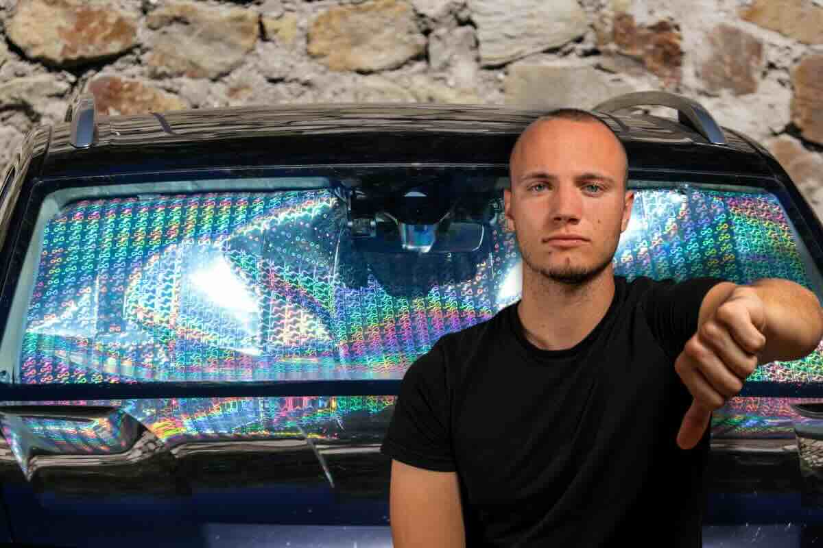 Uomo con pollice in giù, sul retro auto con parasole