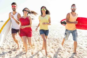 uomini e donne che corrono sulla spiaggia felici