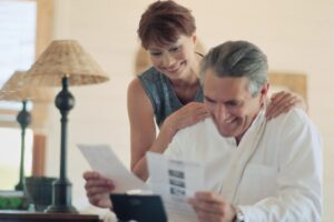 uomo e donna che sorridono mentre leggono dei fogli