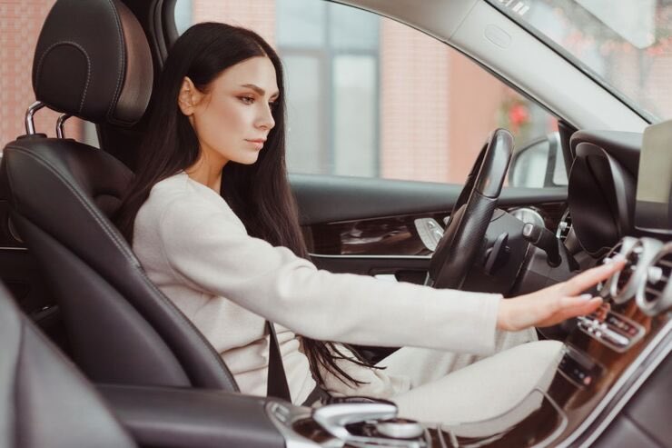 Donna armeggia con aria condizionata in auto
