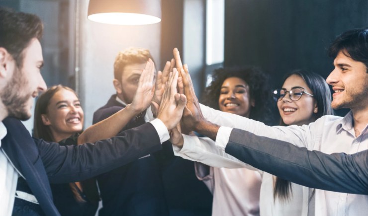 lavoratori felici che battono il 5 con le mani