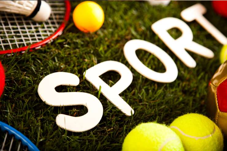 Tanta attrezzatura per i vari sport su un giardino di erba sintetica e la scritta "sport"