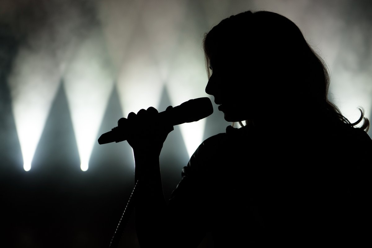 una cantante che canta con il suo microfono anonima, perchè è oscurata