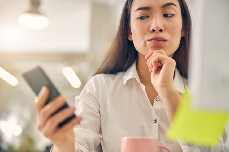 donna che guarda sospettosa il suo cellulare