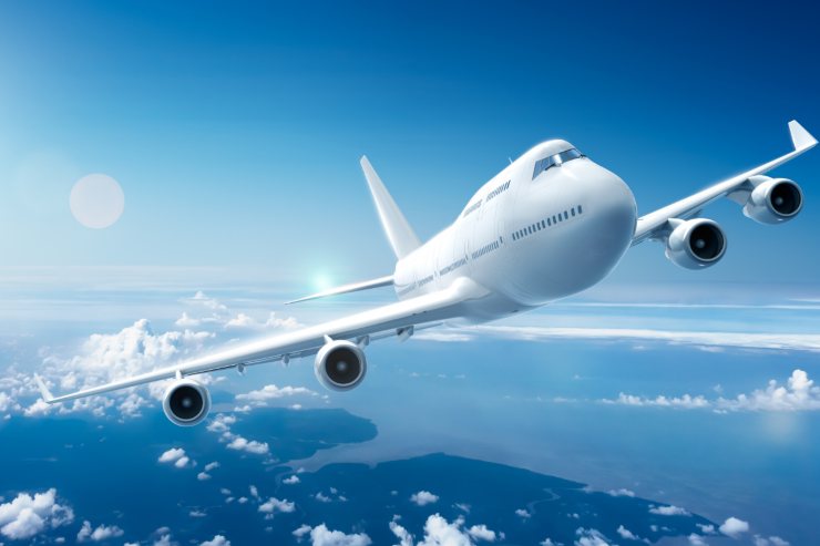 un aereo che sta il volo nel cielo tra le nuvole