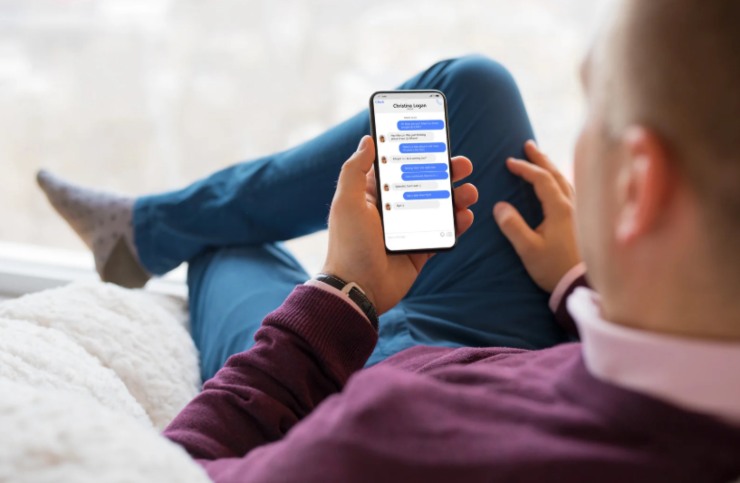 uomo seduto che invia messaggi su whatsapp dal cellulare