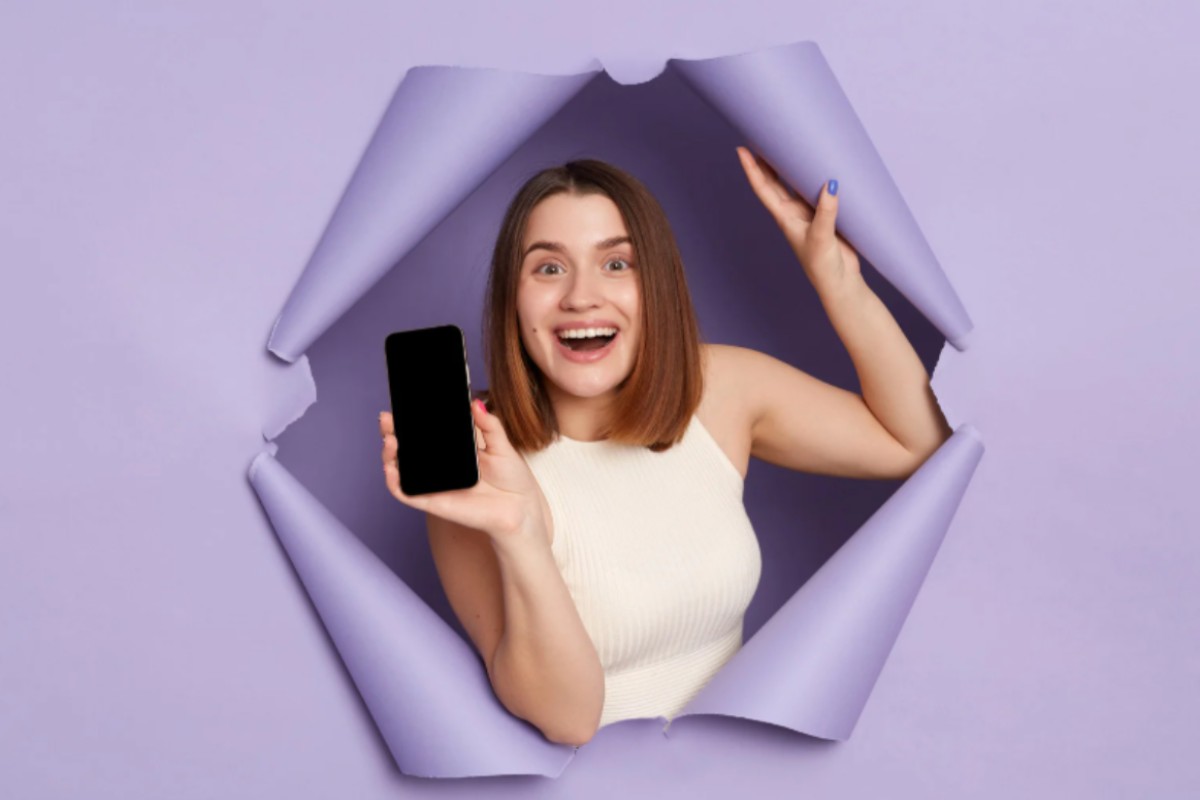donna che sorride con in mano un cellulare