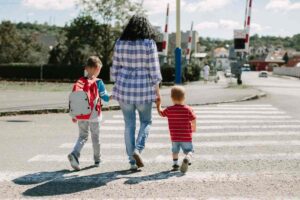 una mamma che attraversa la strada con i figli