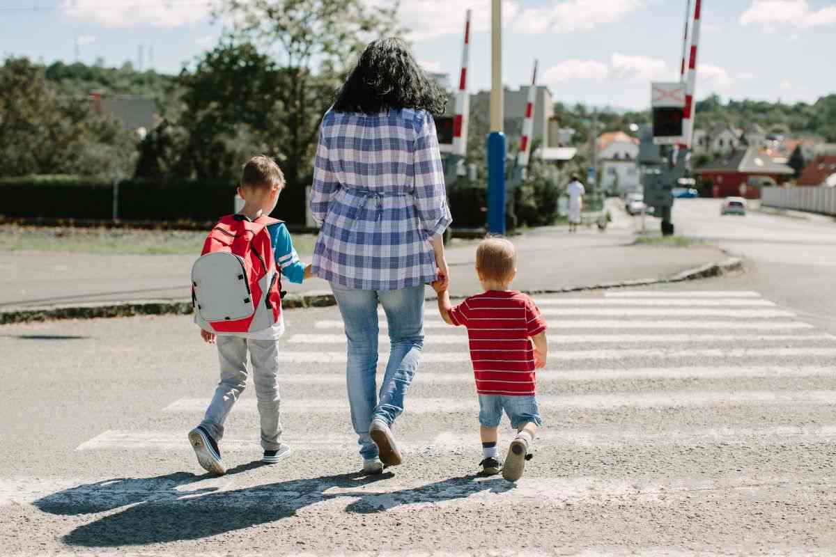 una mamma che attraversa la strada con i figli