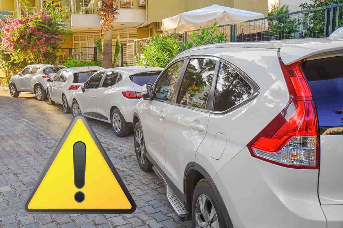 macchine parcheggiate sul marciapiede e il simbolo attenzione