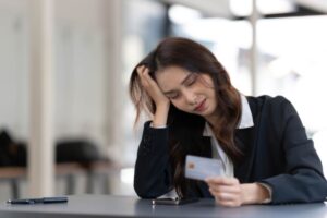 donna triste con una carta di credito in mano