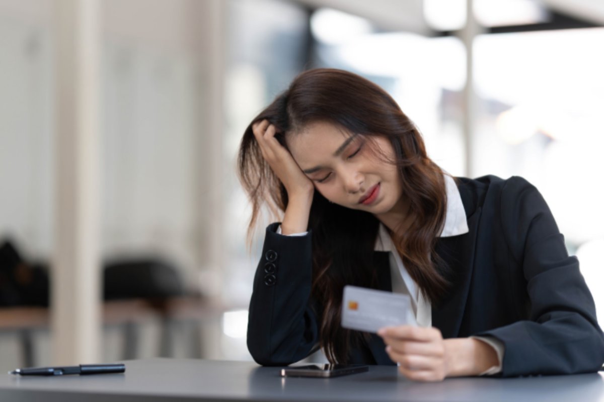 donna triste con una carta di credito in mano