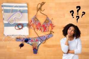 un costume da mare con una ragazza pensierosa e 3 punti interrogativi
