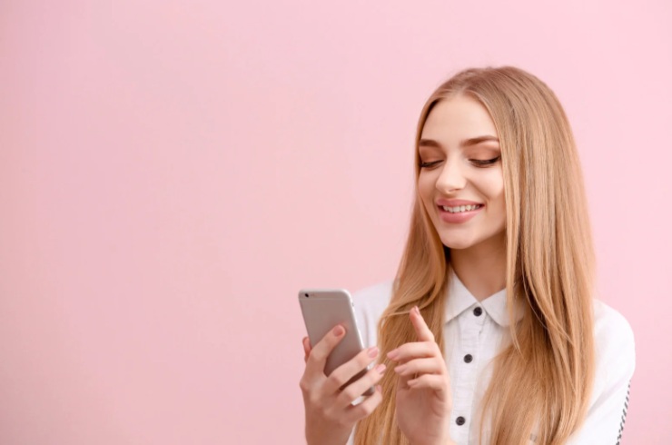 donna che sorride con il cellulare in mano
