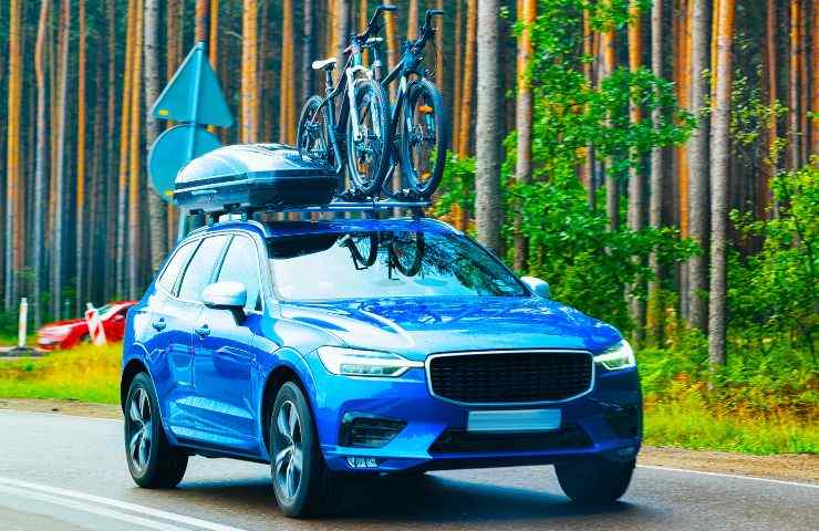una macchina che viaggia con il portapacchi e una bici sul tettino