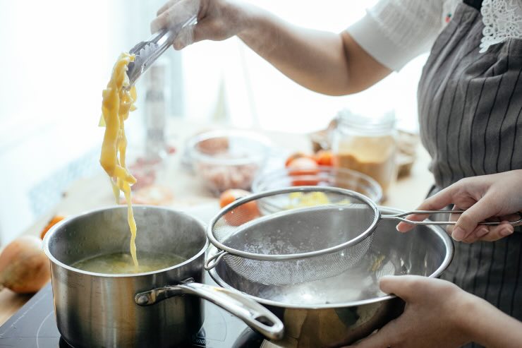 donna che scola pasta