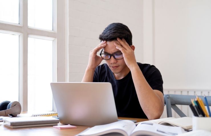 un ragazzo davanti al computer che non riesce a concentrarsi
