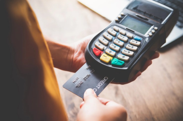 persona che infila una carta di credito dentro al pos