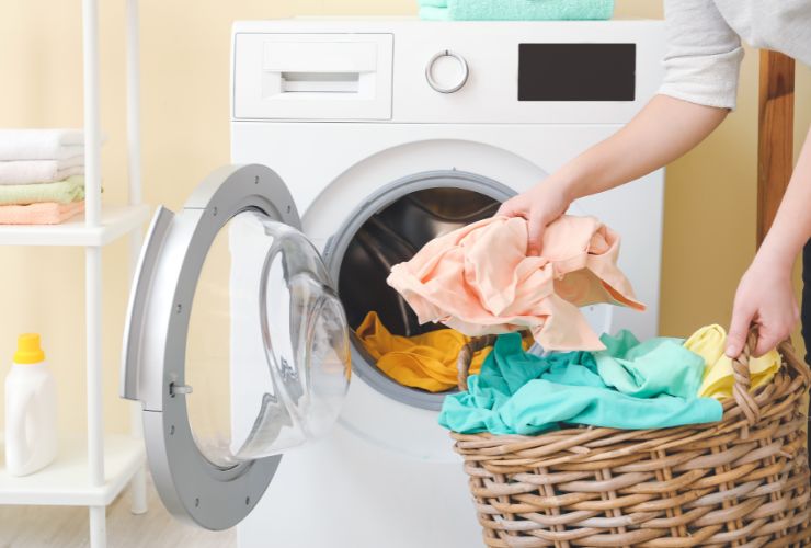 donna che mette bucato in lavatrice 