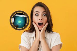 donna stupita con la bocca aperta e le mani sulle guance e nel riquadro l'icona di whatsapp